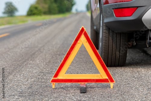 Car breakdown on side of road with warning triangle. Emergency roadside assistance, auto insurance, and vehicle repair concept.