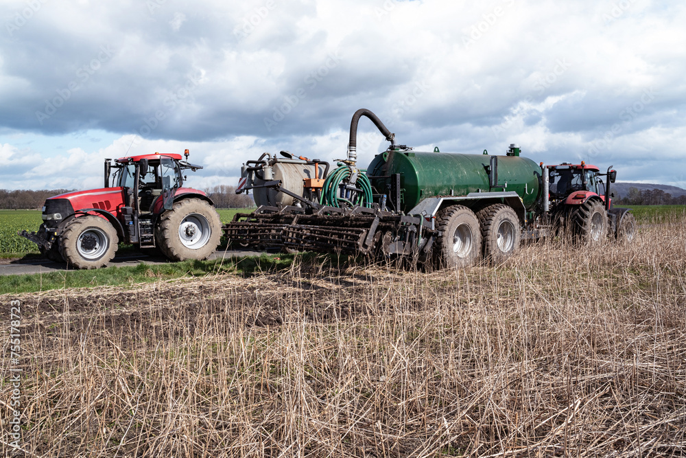 Umpumpen von Gülle aus einem Transportfahrzeug in das Güllefass auf einem Feld im Frühjahr. Umpumpen von Gülle aus einem Transportfahrzeug in das Güllefass auf einem Feld im Frühjahr.