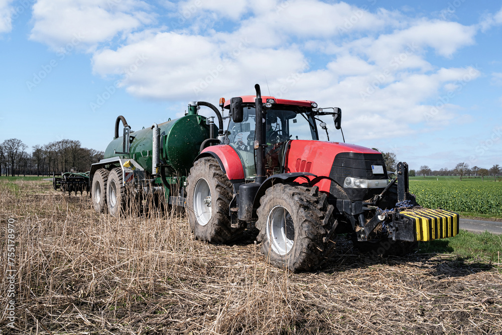 Obraz premium Ausbringung von Gärresten und Gülle einer Biogasanlage aufs Feld im Frühjahr, warten am Wegesrand auf Gülle-Nachschub.