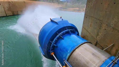 Water outlet from dam wall. Howell Bunger valve in operation. Pressurized water outlet from dam wall. Water flowing from pumping in reservoir. photo