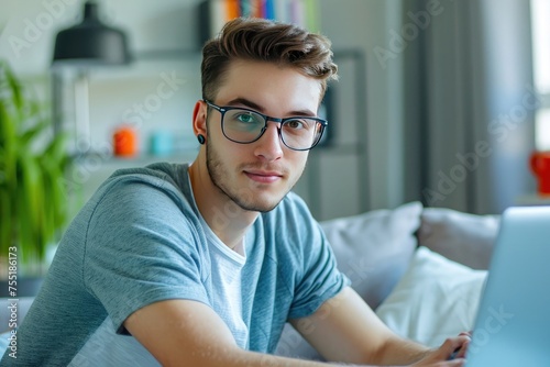 Handsome young man wearing glasses and working with laptop