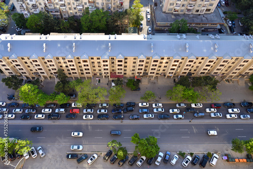 Aerial rooftop view of street with a long residential building and car road in urban area of Baku city