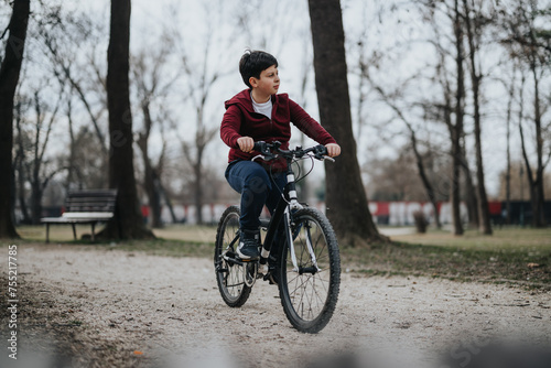 A youthful boy rides his bicycle through a green park, experiencing the joy and freedom of childhood outdoors.