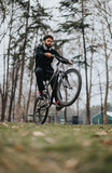 Focused male cyclist on a mountain bike outdoors. Healthy lifestyle, exercise, and outdoor recreation concept in a tranquil forest setting.