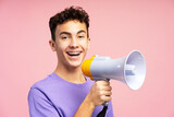 Smiling attractive young boy with braces looking at camera holding and talking into megaphone