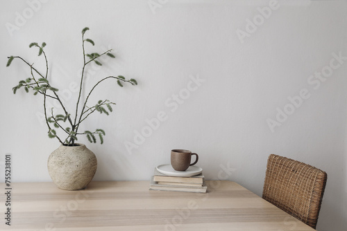 Spring, Easter breakfast still life. Elegant Scandinavian living room, home office. Cup of coffee, books. Wooden desk, table. Vase with willow tree branches, catkins. Blank wall, copy space, no people
