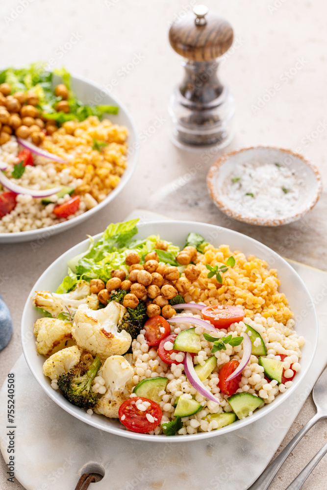 Vegan lunch bowl with roasted vegetables, fresh lettuce, cooked lentils, couscous salad and roasted chickpeas Vegan lunch bowl with roasted vegetables, fresh lettuce, cooked lentils, couscous salad and roasted chickpeas