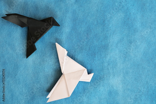 Fotografie Black raven paper origami winning over a white dove