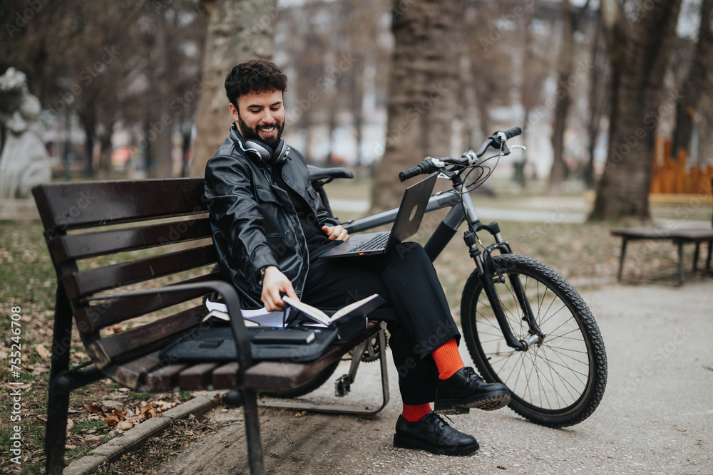 Stylish male entrepreneur multitasking remotely with a laptop and notepad in a city park, accompanied by his bike. Stylish male entrepreneur multitasking remotely with a laptop and notepad in a city park, accompanied by his bike.