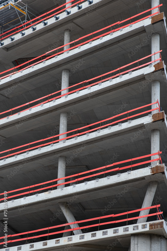 Fototapeta premium Construction of metal concrete structures in architecture, with safety railings on the construction site. real estate development, new architectural floors, columns in construction site.