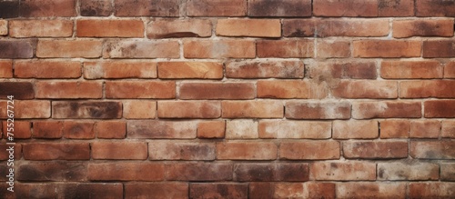 A close-up view of a brown brick wall with no visible mortar  showcasing the raw and unfinished texture of the bricks. The wall exudes a rugged and minimalist aesthetic.