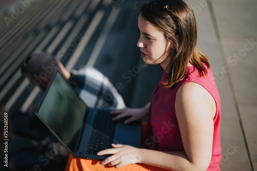 Focused young professionals collaborate using a laptop at a city location, engrossed in a business strategy discussion. Free Download Focused young professionals collaborate using a laptop at a city location, engrossed in a business strategy discussion. - GFXLoad