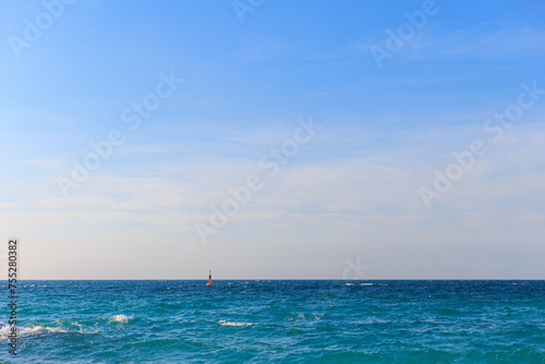 Ocean waves, clear seas and skies, buoys in the sea.