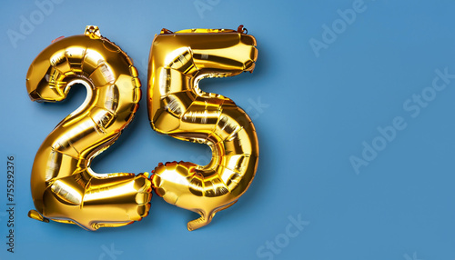 Banner with number 25 golden balloon with copy space. twenty five years anniversary celebration concept on a blue background.
