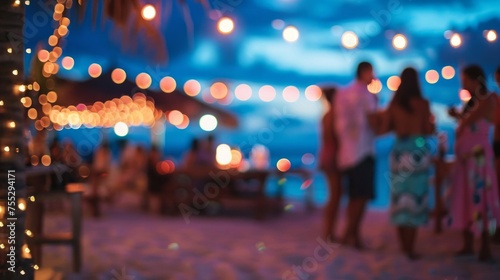 A festive beach party atmosphere captured with colorful defocused lights and blurry figures at dusk.
