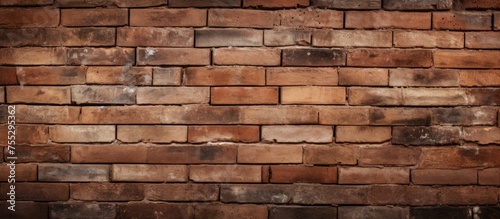A closeup view of a brown brick wall showcasing the intricate brickwork. The rectangular bricks are made of composite materials  resembling a stone wall facade on a building