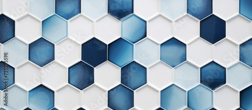Close-up view of a wall covered in white and blue hexagonal tiles, creating a geometric pattern. The tiles are neatly arranged, showcasing a modern and clean design.