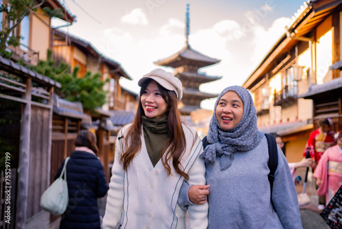 Travel, muslim travel,  woman girl tourist Two Asian friends but different religions walking at Yasaka Pagoda and Sannen Zaka Street in Kyoto Japan, Yasaka Pagoda is the famous landmark and travel. © maya1313