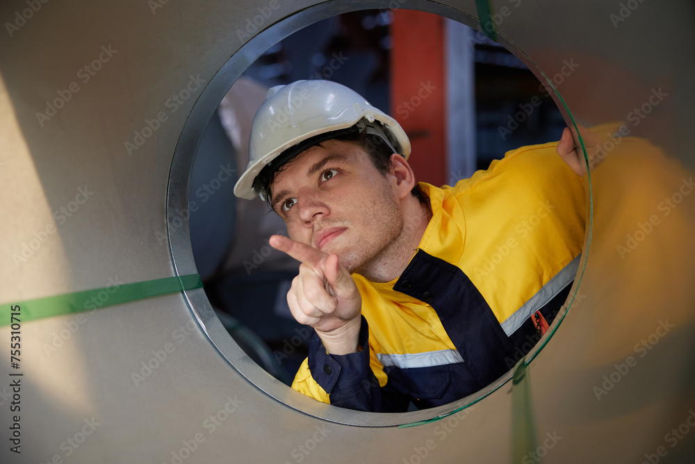 worker or technician checking a roll of industrial aluminum metal material in the factory worker or technician checking a roll of industrial aluminum metal material in the factory