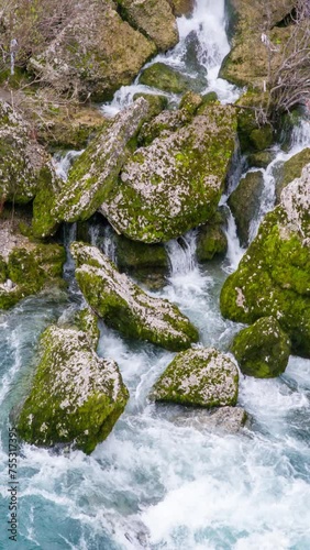 Water stream flowing on green mossy stones - mountain landscape with waterfall brook cascades. Natural resource conservation and environmental protection.