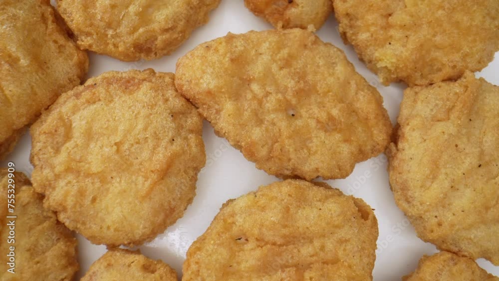 Chicken nuggets are bite-sized pieces of chicken meat that are breaded and fried until golden brown. They are a popular fast food and snack item enjoyed by people of all ages. Fast-food background.
Chicken nuggets are bite-sized pieces of chicken meat that are breaded and fried until golden brown. They are a popular fast food and snack item enjoyed by people of all ages. Fast-food background.