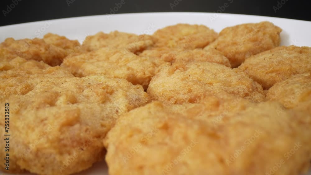 Chicken nuggets are bite-sized pieces of chicken that are breaded and fried until crispy. They are a popular fast food and snack option, loved by both children and adults alike. Food background. 4K.
Chicken nuggets are bite-sized pieces of chicken that are breaded and fried until crispy. They are a popular fast food and snack option, loved by both children and adults alike. Food background. 4K.