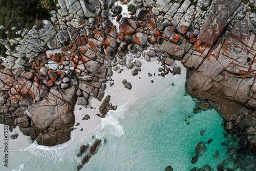 Aerial view of the Bay of fires in Tasmania. Beautiful coastline with orange rocks, white sand and transparent blue water. Drone footage in Australia.