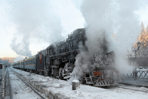 The locomotive has arrived at the railway station and is standing steam. View of a black retro train at Ruskeala station.