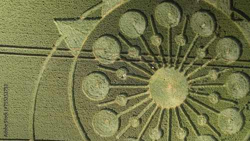 Intricate crop circle design in farm land in Owslebury, top-down aerial trucking photo