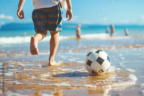 close view of Young father with his little son playing football on the beach sea