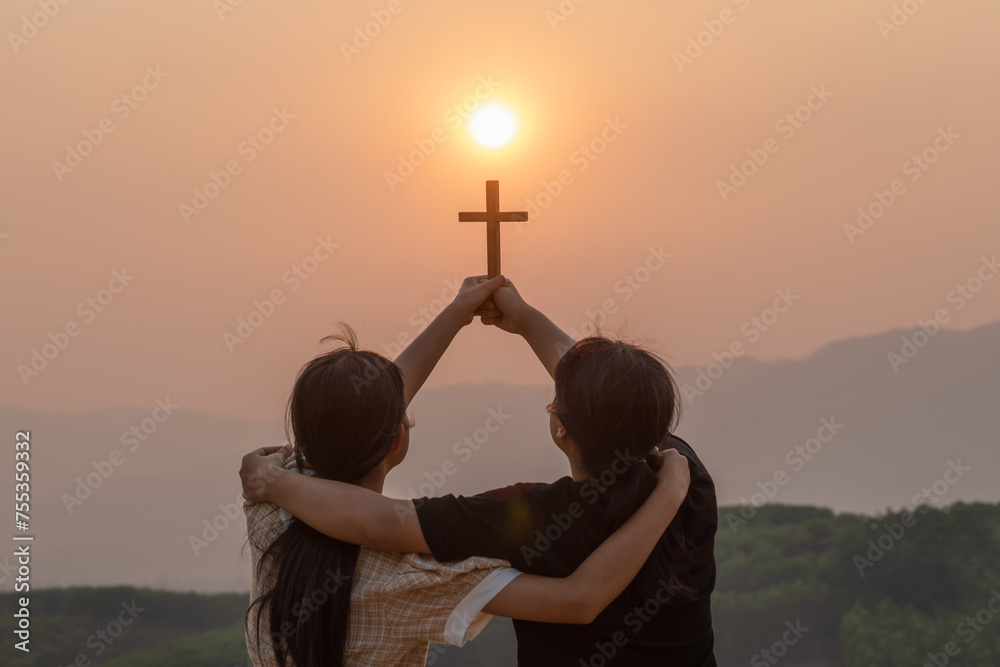 Silhouette two girl together hug with holding christian cross for ...