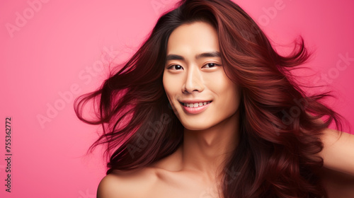 Handsome young male guy smile Asian with long red hair, on pink background, banner, copy space, portrait.