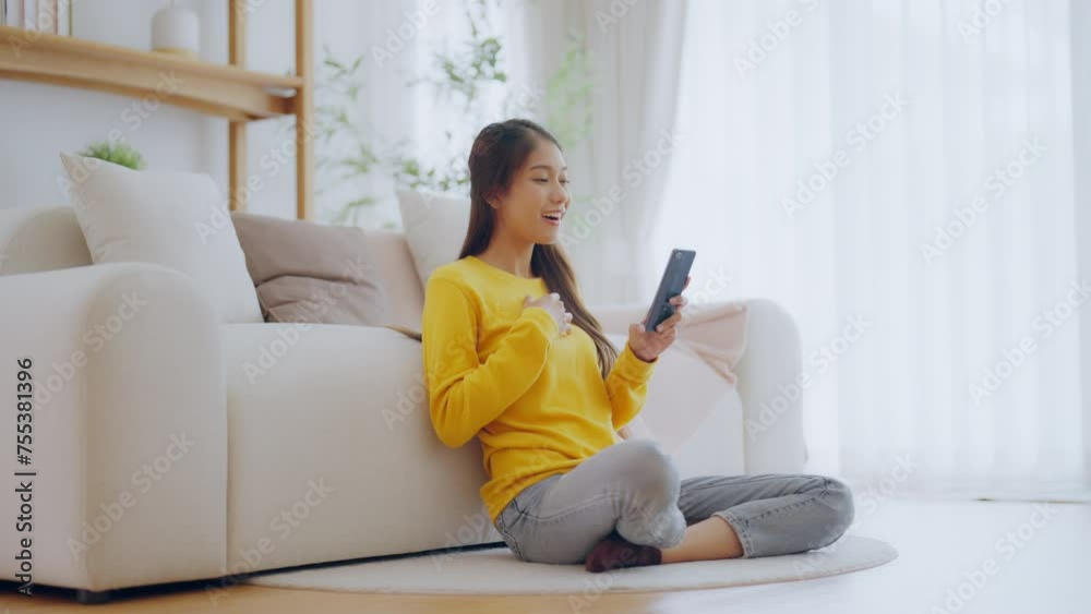 Happy young asian woman relax on comfortable couch at home texting messaging on smartphone, smiling girl use cellphone chatting, online shopping at home, video call communication Happy young asian woman relax on comfortable couch at home texting messaging on smartphone, smiling girl use cellphone chatting, online shopping at home, video call communication