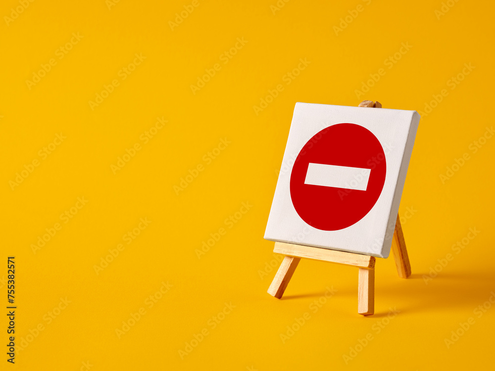A canvas with no entry sign on an easel with yellow background with copy space. A canvas with no entry sign on an easel with yellow background with copy space.