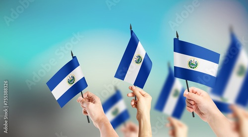 Fototapeta Naklejka Na Ścianę i Meble -  A group of people are holding small flags of El Salvador and Tobago in their hands.