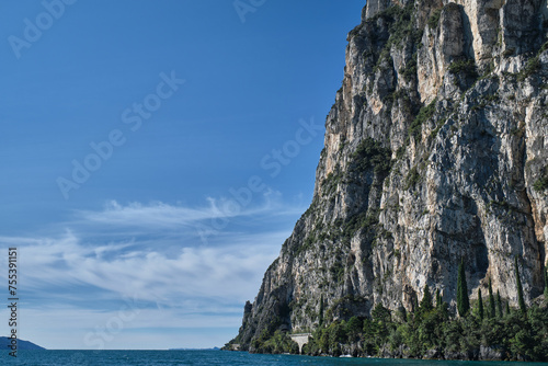 Fototapeta Naklejka Na Ścianę i Meble -  Rough rocky stones. Red rocks on a blue background. Gray rocky slopes in the water. Alps part on blue sky.