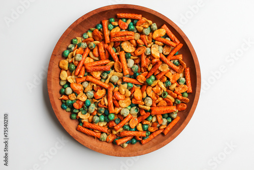 Mixed peanut and snacks, on wooden plate, isolated on white background, flat lay or top view photo
