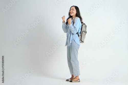 backview full leght shoot of happy asian Indonesian woman wearing casual attire and backpack on isolated background photo