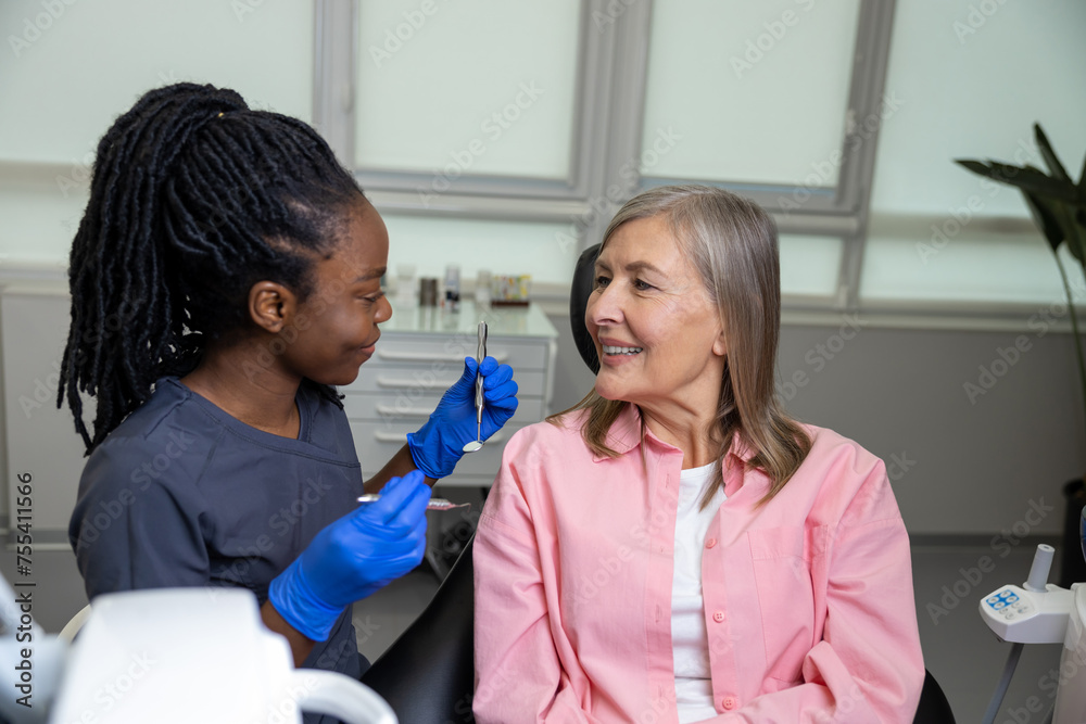 Doctor holding instrument tool for oral examination of middle aged female patient Doctor holding instrument tool for oral examination of middle aged female patient
