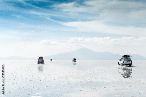 Off-road cars driving on Salar de Uyuni salt flat in Bolivia.