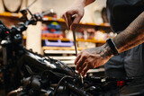 Closeup image of repairman with wrench fixing motorcycle part