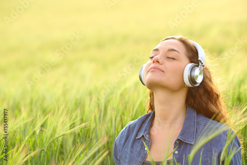 Woman meditating listening guided tutorial in nature