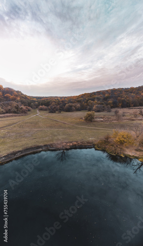 Aerial vertical panorama on river in autumn valley with epic cloudy sky in Ukraine