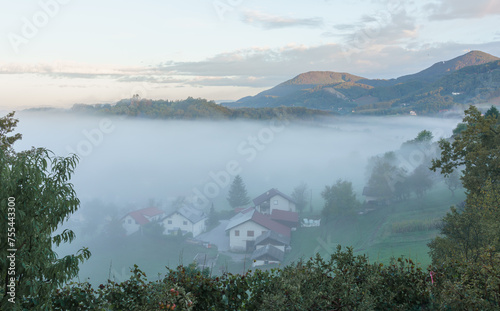 Fog in the mountains early in the morning. Mountain village in Slovenia, Europe.