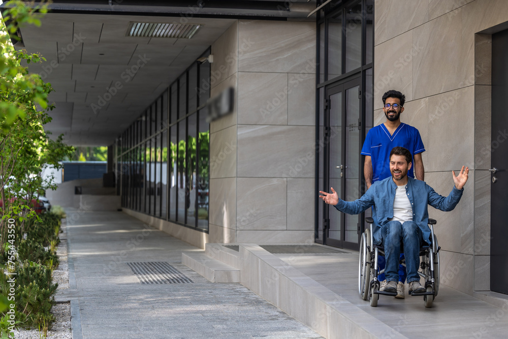 Dark-haired male nurse carrying a wheelchair with a young man