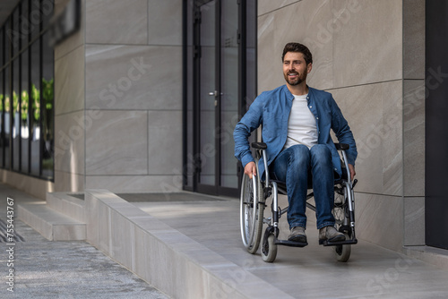 Young bearded man riding a wheelchair in a hospital yard © zinkevych