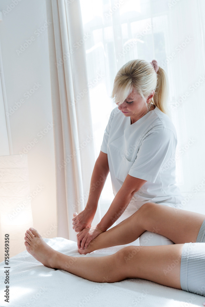 Chiropractor doing chiropractic massage on patient's foot in treatment room Chiropractor doing chiropractic massage on patient's foot in treatment room