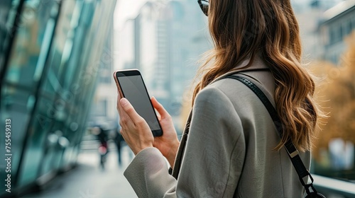 A businesswoman uses a smartphone, close up on hand, top view, back over shoulder camera angle, daylight, Ai Generated.