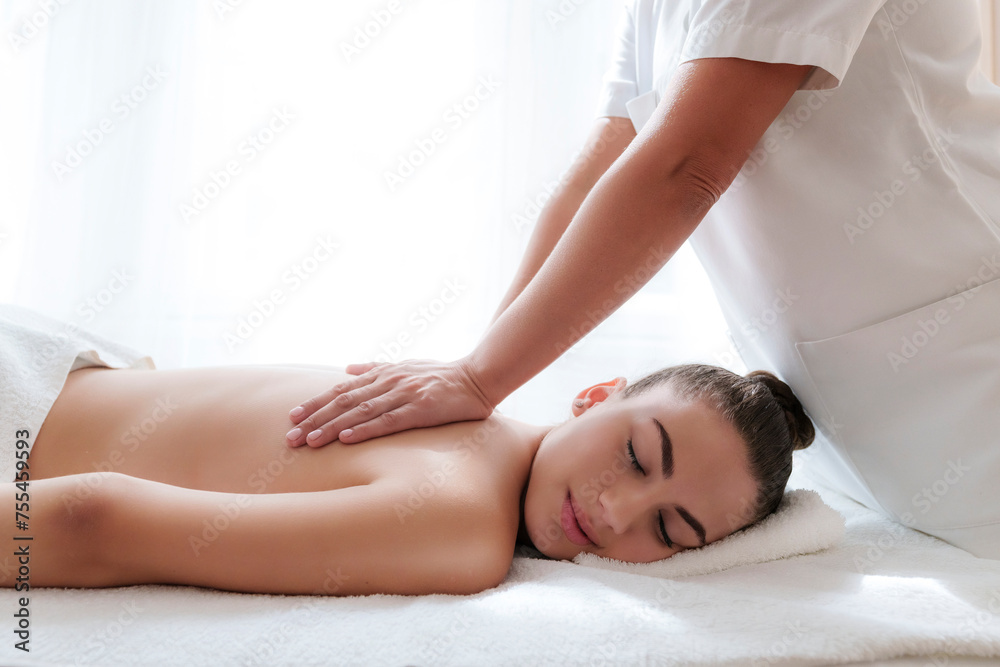 Physical therapist massaging patient's back in treatment room Physical therapist massaging patient's back in treatment room