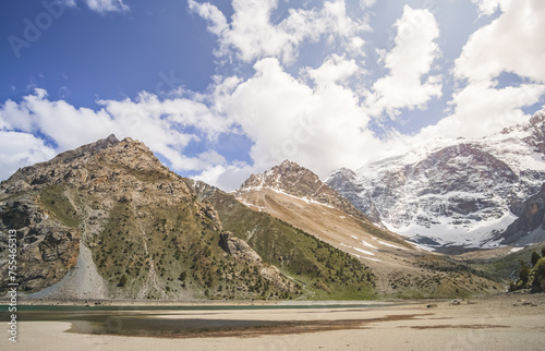 River and lake Kulikalon against the backdrop of rocky mountains with glaciers in the Fan Mountains in Tajikistan, clear blue water of the lake photo